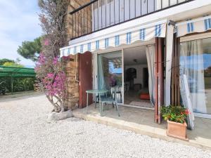 eine Terrasse eines Hauses mit einem Tisch und Blumen in der Unterkunft Studio cosy à 200m de la plage Parking & Wi-Fi in Bormes-les-Mimosas