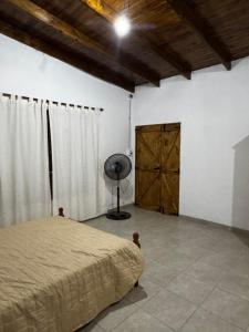 a bedroom with a bed and a fan and a door at No alquilar in Cucullú