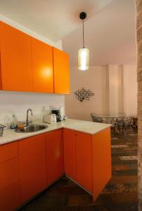 eine orangefarbene Küche mit einem Waschbecken und einem Tisch in der Unterkunft Casa Maralta in Panama-Stadt + 4 Fotos