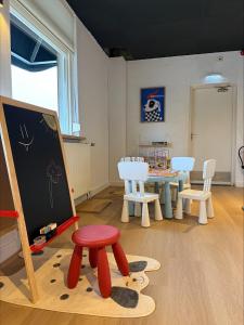 a classroom with a table and a stool and a chalkboard at Hotel Emilia in Kaatsheuvel +46 photos