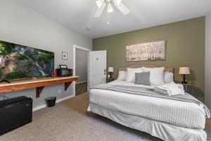 a bedroom with a large bed and a flat screen tv at NEW King Bed,Suite,Downtown BR Southern Charm Boxcar in Blue Ridge