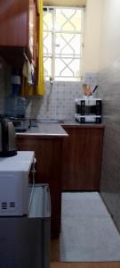 a kitchen with a counter and a sink and a window at Naivasha Studio- Rated Best in Naivasha