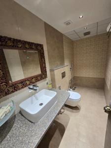 ein Badezimmer mit Waschbecken und Toilette in der Unterkunft Hotel Surya Palace in Gandhinagar