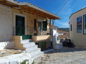 梅加尼西岛Xeni's House的旁边设有楼梯和摩托车的房屋