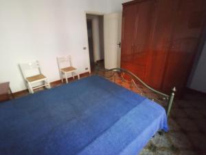 una camera con un letto blu e due sedie di Gallipoli Lido San Giovanni vicino spiaggia a Gallipoli