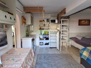 a small room with a bed and a kitchen at Blaha Lujza Apartman Balaton in Alsóörs