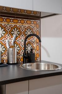 un bancone della cucina con lavandino e parete di Tra i vicoli di Napoli, La Olivella design e amore a Napoli Altre 22 foto