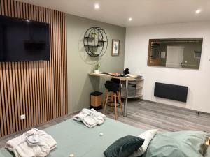 a room with a bed and a desk and a television at Ôbulles in Tilloy-lès-Conty