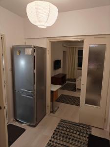 a kitchen with a stainless steel refrigerator in a room at Renovated handy spacious 3 room apartment for tourists, workers and students in Rauma