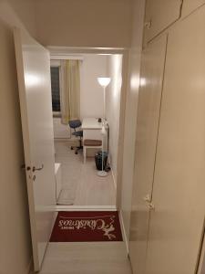 a hallway with a door open to a room with a desk at Renovated handy spacious 3 room apartment for tourists, workers and students in Rauma