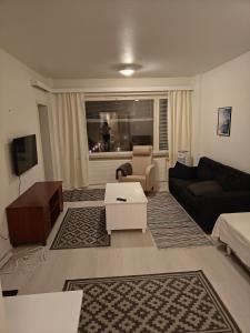 a living room with a couch and a table at Renovated handy spacious 3 room apartment for tourists, workers and students in Rauma