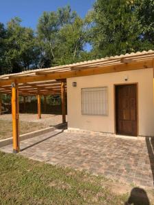 ein Gebäude mit einer Garage mit einer Tür und einer Terrasse in der Unterkunft Casita del Río in Santa Rosa de Calamuchita
