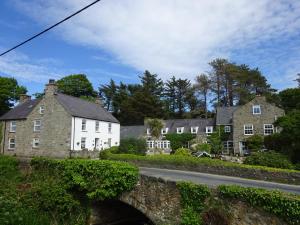 an old stone bridge over a road with houses at Yr Hen Felin - The Old Mill B&B in Morfa Nefyn