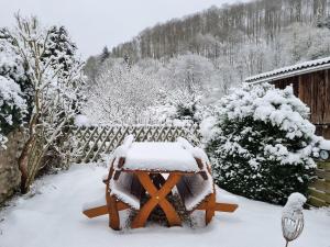 a snow covered table in a yard with a fence at Ferienhaus Inge in Stolberg