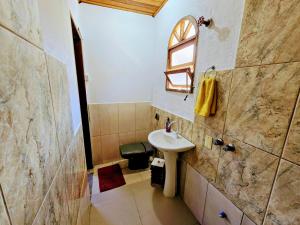 un bagno con lavandino e specchio di Suíte privativa acesso rápido 5 minuto balsa a Ilhabela