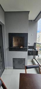 uma sala de estar com uma lareira e uma mesa em Apartamento 3 quartos com suíte em Itapema