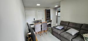 uma sala de estar com um sofá e uma mesa em Apartamento 3 quartos com suíte em Itapema