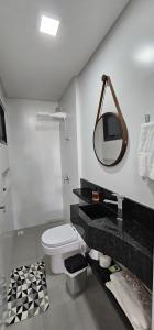 uma casa de banho com um WC e um espelho na parede em Apartamento 3 quartos com suíte em Itapema mais 10 fotografias