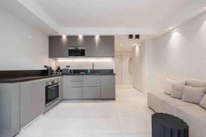 a kitchen and living room with a couch and a table at La suite Versailles Croisette in Cannes