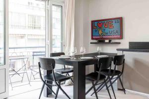 a dining room with a black table and chairs at La suite Versailles Croisette in Cannes