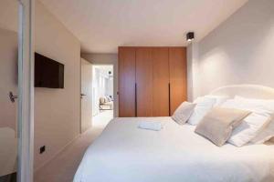 a bedroom with a large white bed with white pillows at La suite Versailles Croisette in Cannes +3 photos