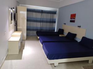 a small room with two beds and a window at Aquarium Seaview accomodations in Hurghada