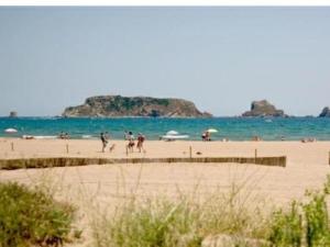 a group of people walking on a beach at SunandSea in L'Estartit +5 photos