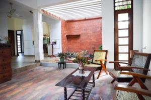 a living room with a brick wall and a table at Olive Green Villa in Negombo for Airport Transit in Katunayaka