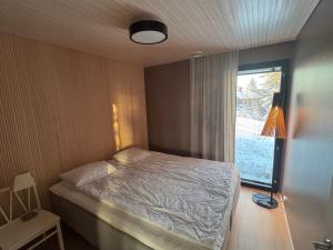 a small bedroom with a bed and a window at Himos Villa Aurinkorinne in Jämsä