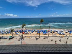 a view of a beach with umbrellas and the ocean at Farol Barra Flat in Salvador