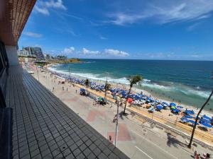 a view of a beach with umbrellas and the ocean at Farol Barra Flat in Salvador
