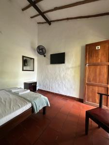 a bedroom with a bed and a tv on the wall at Mi Ranchito, Centro in Barichara +18 photos