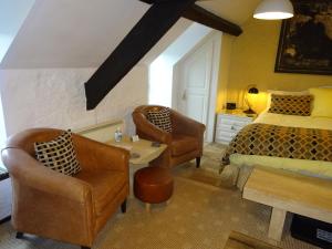 a bedroom with a bed and two chairs at Yr Hen Felin - The Old Mill B&B in Morfa Nefyn