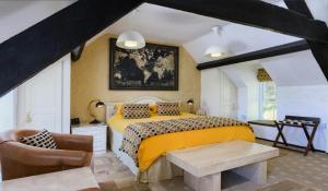 a bedroom with a yellow bed and a chair at Yr Hen Felin - The Old Mill B&B in Morfa Nefyn