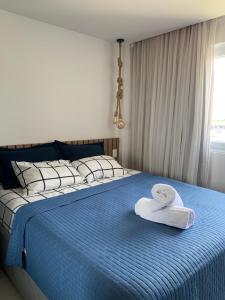 un letto con una coperta blu e un cappello sopra di Praia de Guarajuba -BA, paz e água fresca a 900 m praia ! a Camassari Altre 67 foto