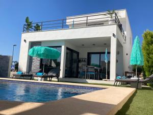 a villa with a swimming pool next to a house at micasa in Denia