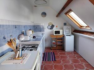 a kitchen with a stove and a refrigerator at Les Pins, plage à pied in Fouesnant