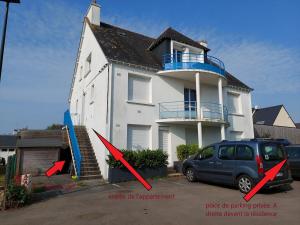 a white house with two red arrows in front of it at Les Pins, plage à pied in Fouesnant +2 photos
