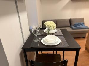 a black table with plates and glasses and a couch at Apartamenty Rybna 1 Centrum in Tarnów +12 photos