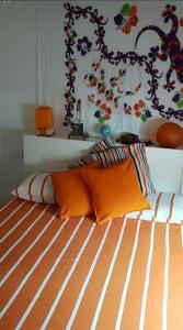 1 cama con almohadas de color naranja en el dormitorio en Two steps from Val Grande- The Foliage Train, en Domodossola