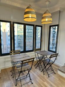 two tables and chairs in a room with windows at Hostal Zaragoza Centro in Zaragoza