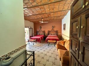 a room with two beds with red sheets at Casa de Alegria in Lo de Marcos