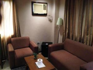 a living room with a couch and a chair and a table at Hidden Pearl Hotel (Janus Luxury Suites) in Angeles