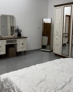 a bedroom with a bed and a dresser and mirror at Asayl resort in Baghdad +4 photos