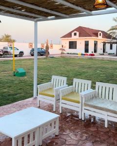 a group of white benches sitting on a patio at Asayl resort in Baghdad