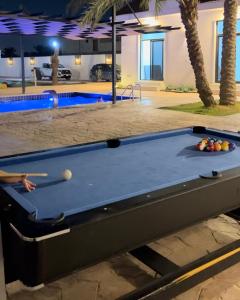 a pool table in front of a swimming pool at Asayl resort in Baghdad