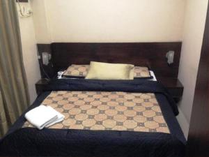 a small bedroom with two beds with blue sheets at Hidden Pearl Hotel (Janus Luxury Suites) in Angeles