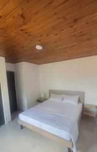 a bedroom with a white bed with a wooden ceiling at Hermoso moderno Duplex en El Sur de Cali in Cali