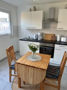 a kitchen with a table with a vase of flowers on it at Ferienhuus Tüütje in Wolthusen