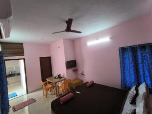 a bedroom with a bed and a table and a ceiling fan at La villa Rani KK Nagar in Madurai